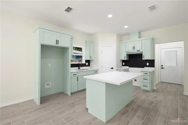 a kitchen with white cabinets appliances and sink