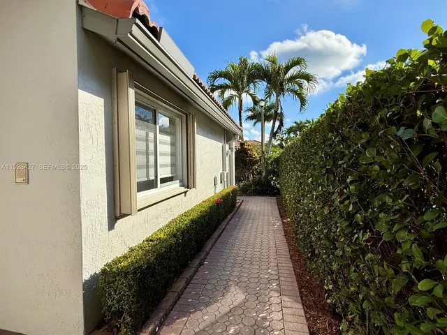 a view of a house with a large window and potted plants