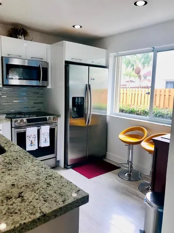 a kitchen with stainless steel appliances granite countertop a stove a refrigerator and a microwave