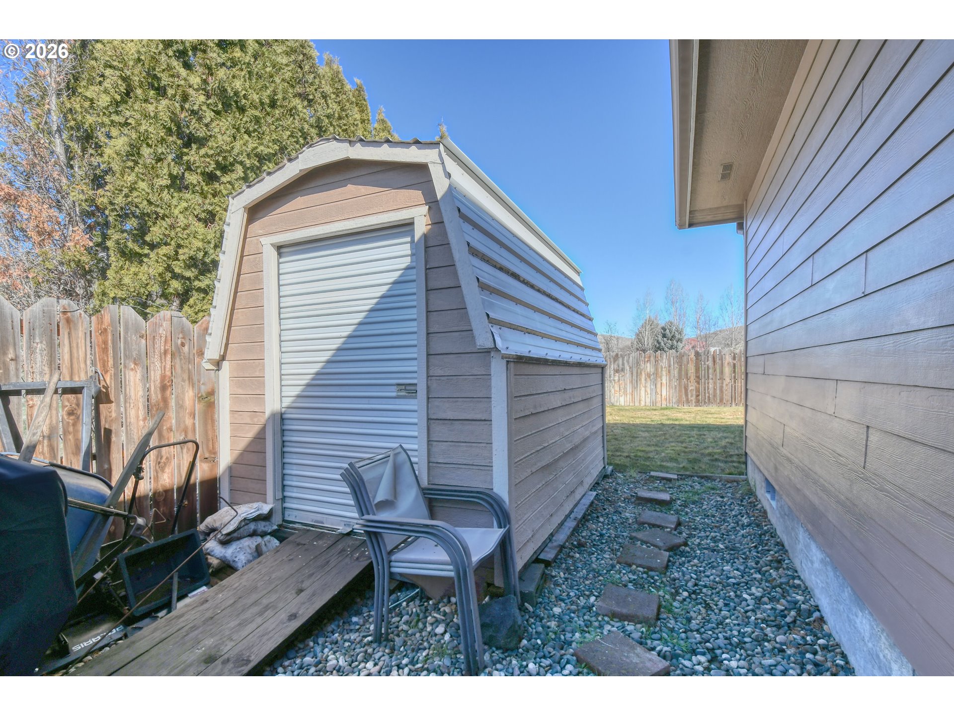 2175 Northwest Gilliam Avenue Pendleton, OR 97801 - Photo 35 of 36 a backyard of a house with large trees and brick walls