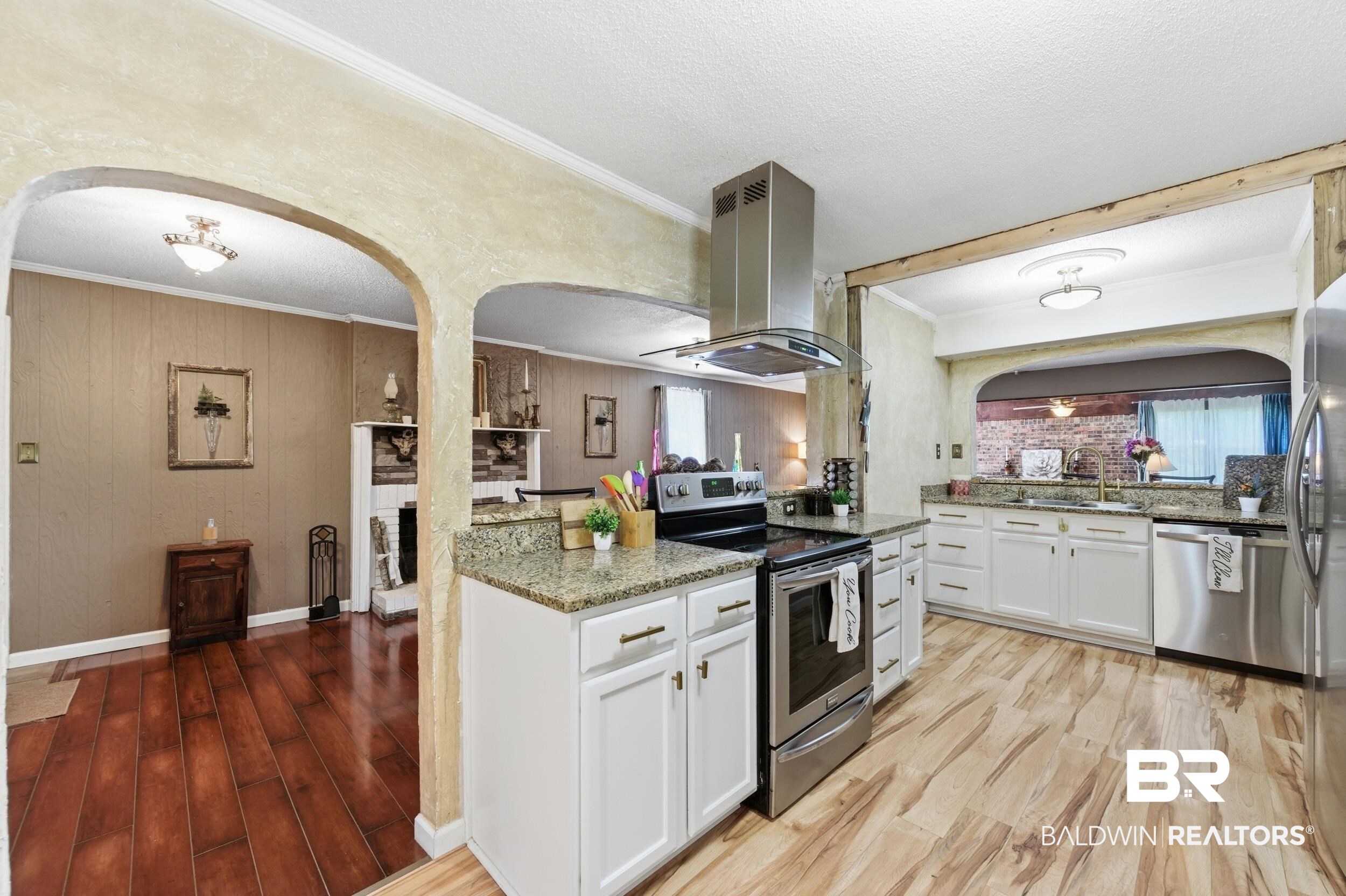 51620 Robert White Road Bay Minette, AL 36507 - Photo 34 of 81 Kitchen featuring a central island with countertop seating, white cabinetry with contemporary hardware, stainless steel appliances, and a stainless steel range hood