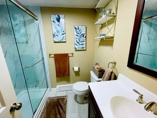 a bathroom with a sink and mirror with toilet
