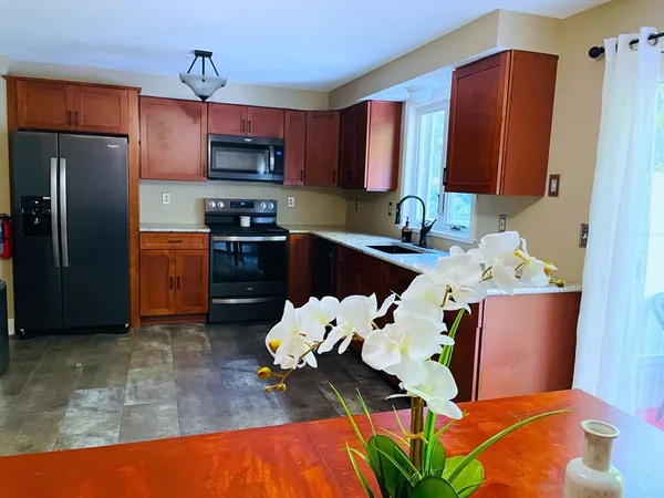 a kitchen with stainless steel appliances granite countertop a refrigerator sink and stove