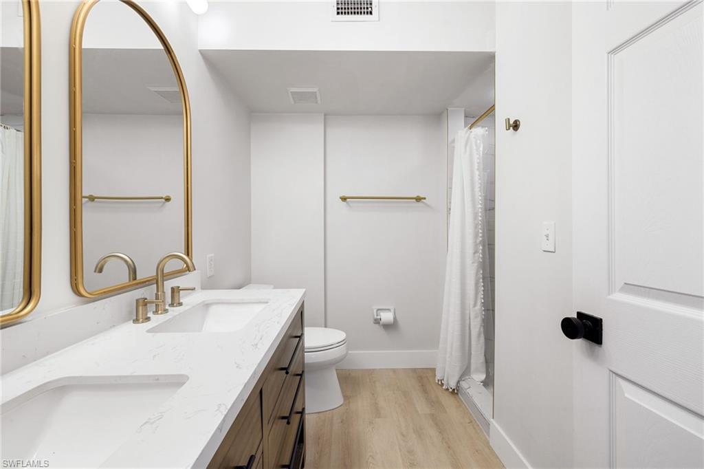 165 Wading Bird Circle, Unit M106 Naples, FL 34110 - Photo 14 of 23 a bathroom with a sink a toilet and a mirror