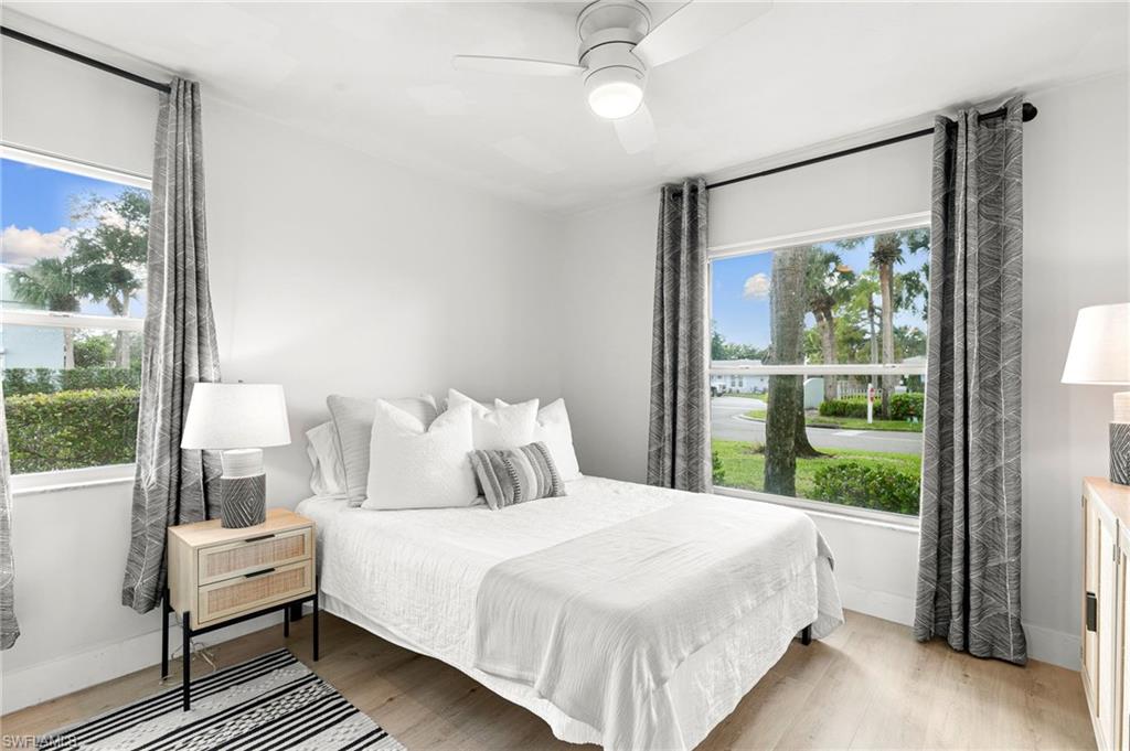 165 Wading Bird Circle, Unit M106 Naples, FL 34110 - Photo 15 of 23 a bedroom with a large bed and a window