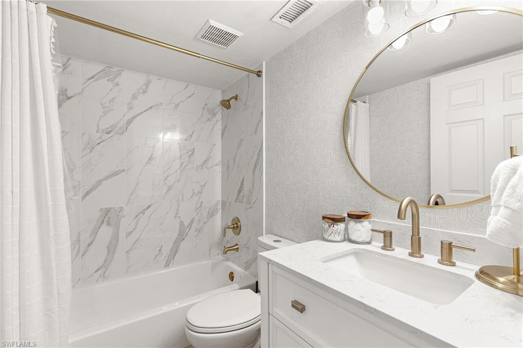 165 Wading Bird Circle, Unit M106 Naples, FL 34110 - Photo 17 of 23 a bathroom with a sink a toilet and a mirror