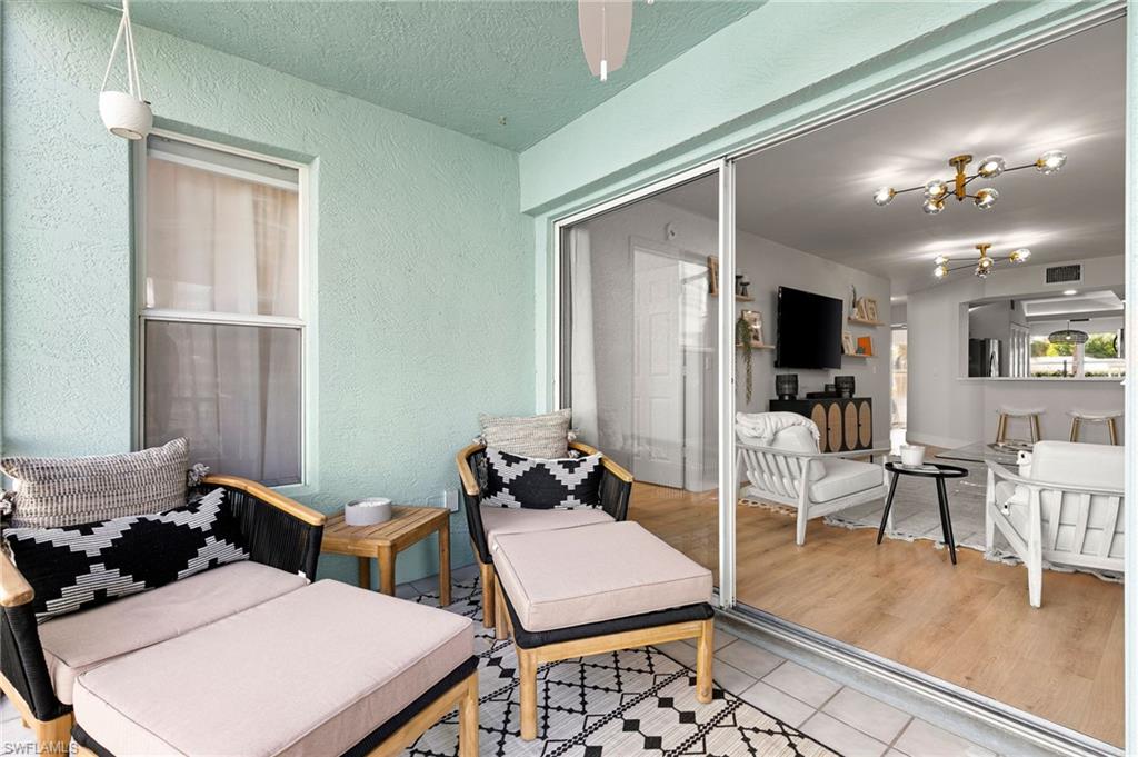 165 Wading Bird Circle, Unit M106 Naples, FL 34110 - Photo 20 of 23 a living room with furniture and wooden floor