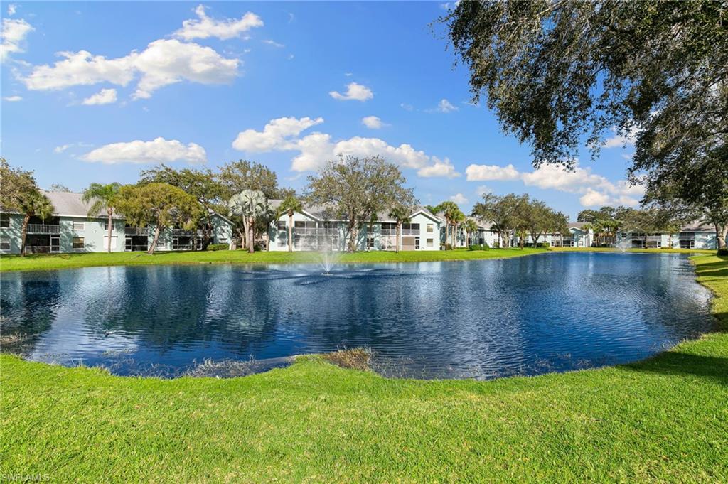 165 Wading Bird Circle, Unit M106 Naples, FL 34110 - Photo 21 of 23 a view of a lake with houses in the background