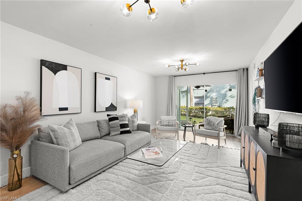 165 Wading Bird Circle, Unit M106 Naples, FL 34110 - Photo 5 of 23 a living room with furniture and a flat screen tv