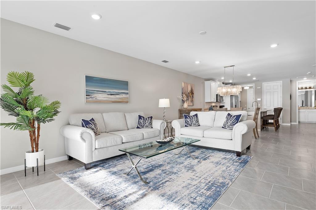14558 Edgewater Circle Naples, FL 34114 - Photo 3 of 40 a living room with furniture potted plant and a lamp