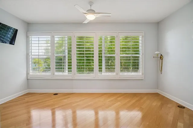 a view of an empty room with a window and a kitchen area