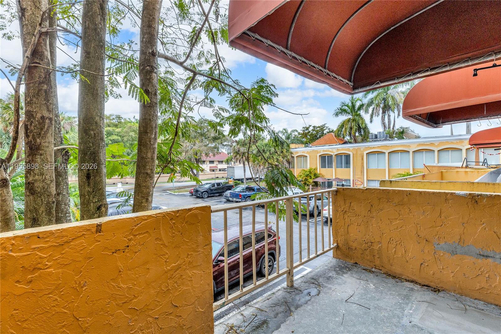 17901 Northwest 68th Avenue, Unit T206 Hialeah, FL 33015 - Photo 22 of 27 a balcony with wooden floor and outdoor space