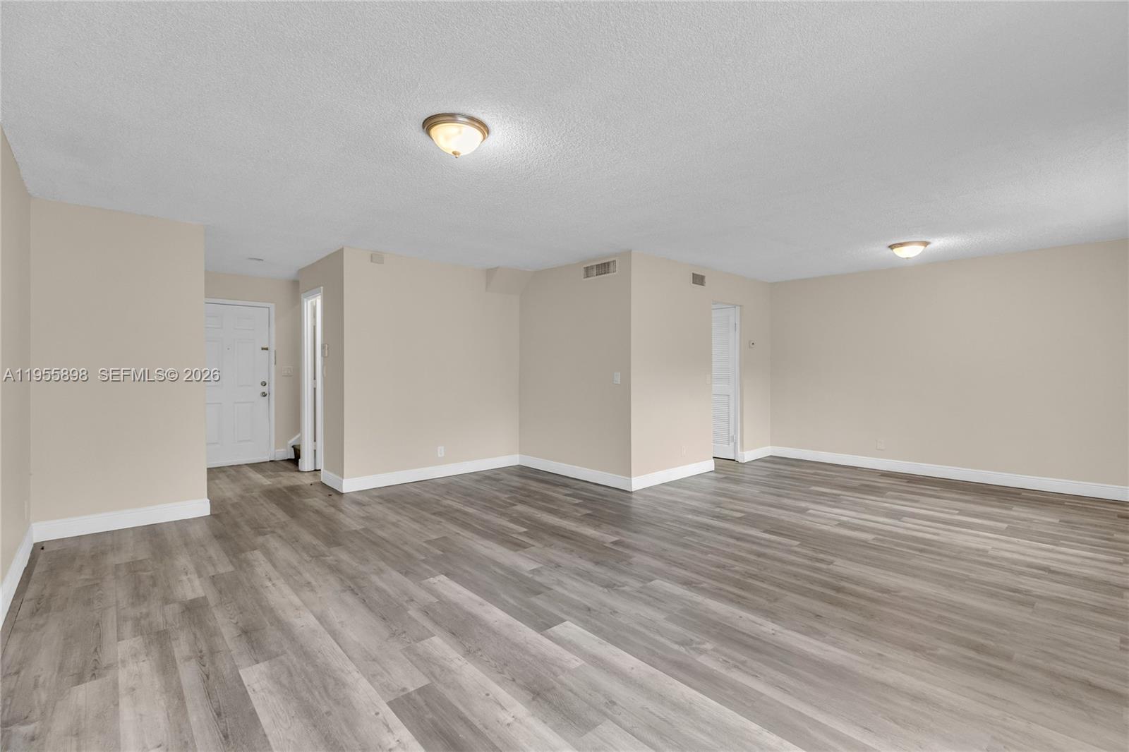 17901 Northwest 68th Avenue, Unit T206 Hialeah, FL 33015 - Photo 3 of 27 a view of an empty room with wooden floor