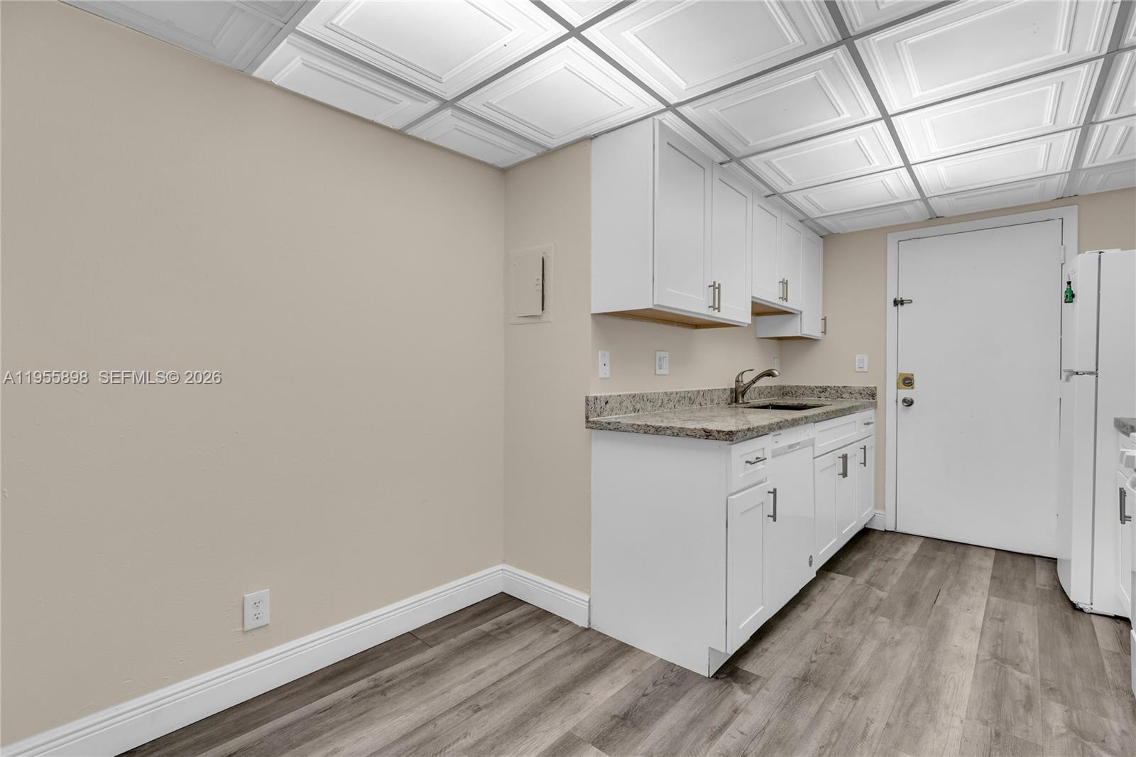 17901 Northwest 68th Avenue, Unit T206 Hialeah, FL 33015 - Photo 6 of 27 a kitchen with granite countertop white cabinets and white appliances