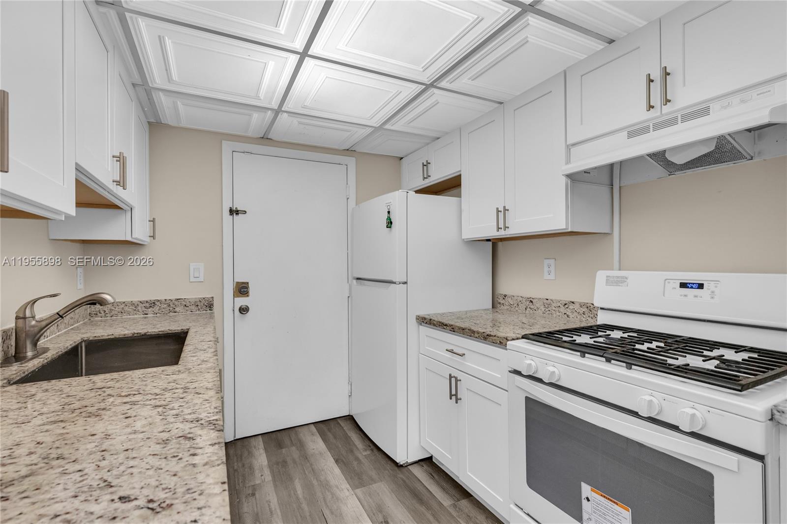 17901 Northwest 68th Avenue, Unit T206 Hialeah, FL 33015 - Photo 7 of 27 a kitchen with granite countertop a sink stove and refrigerator