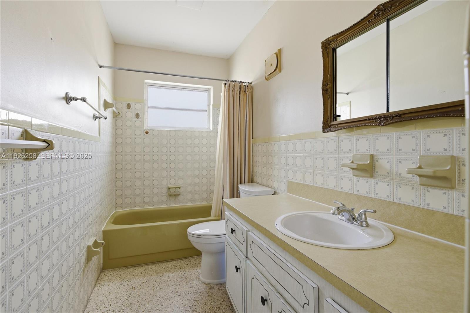 10551 Southwest 27th Street Miami, FL 33165 - Photo 23 of 35 a bathroom with a granite countertop sink a toilet a mirror and bathtub
