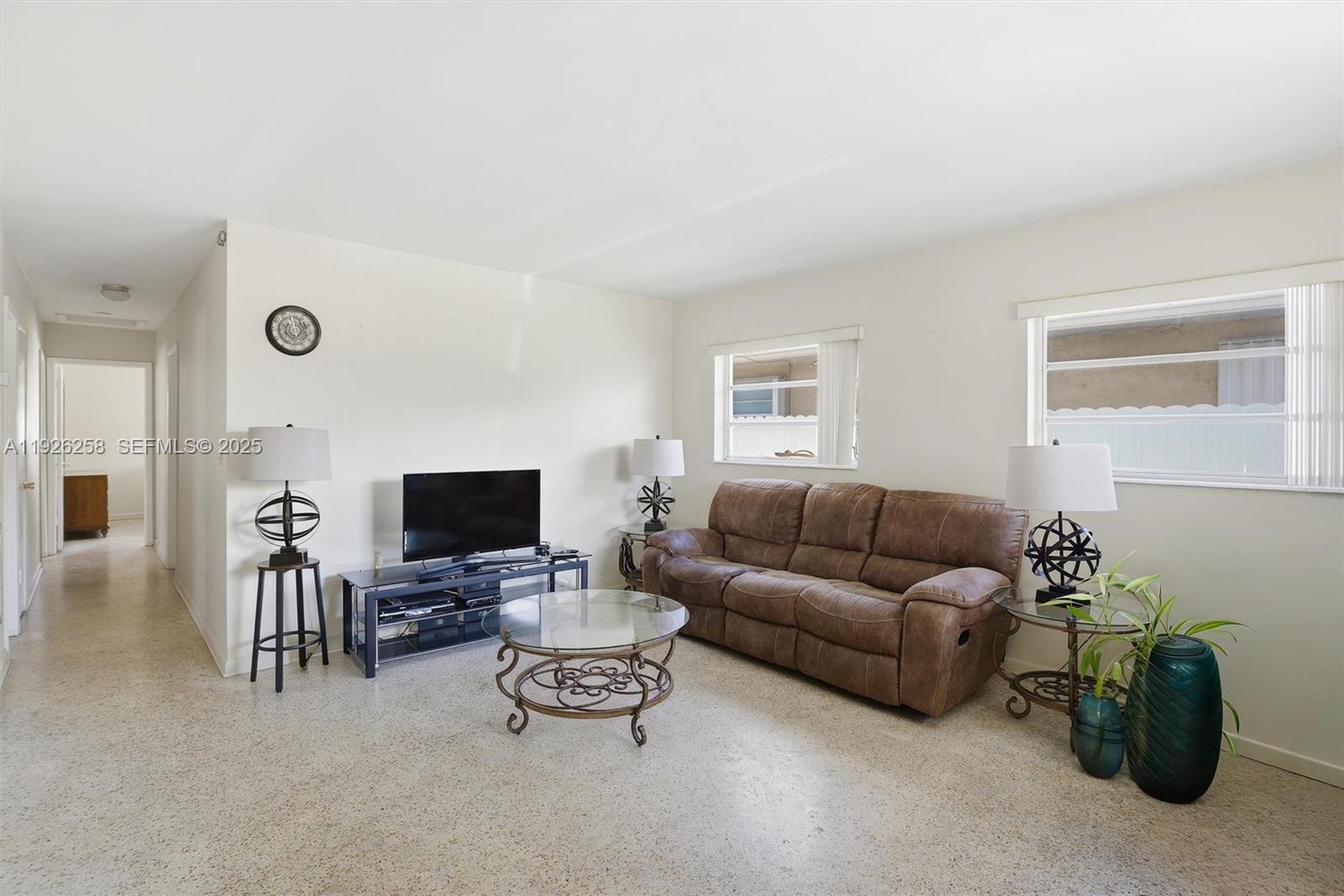 10551 Southwest 27th Street Miami, FL 33165 - Photo 10 of 35 a living room with furniture a flat screen tv and a window