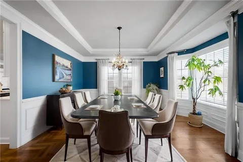 a view of a dining room with furniture a chandelier and wooden floor