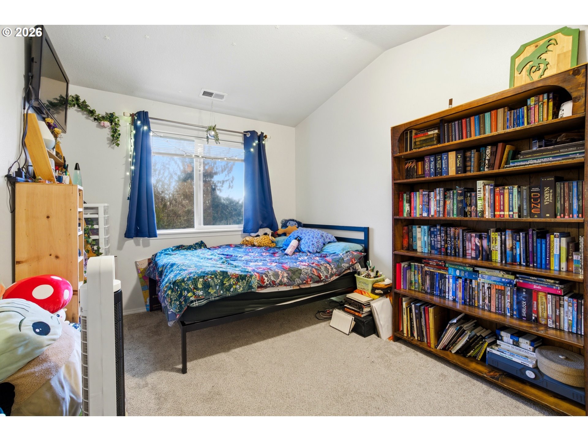 7159 Southwest Millennium Terrace Beaverton, OR 97007 - Photo 18 of 24 a bedroom with a bed a book shelf and a book shelf