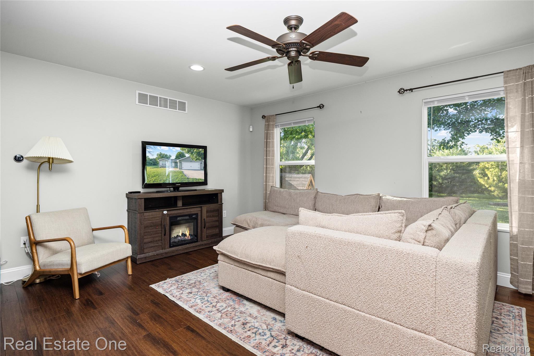 2479 Gibson Road Grand Blanc, MI 48439 - Photo 14 of 55 Living area featuring rich wood-finish flooring, light gray wall paint, and a built-in media console with an electric fireplace