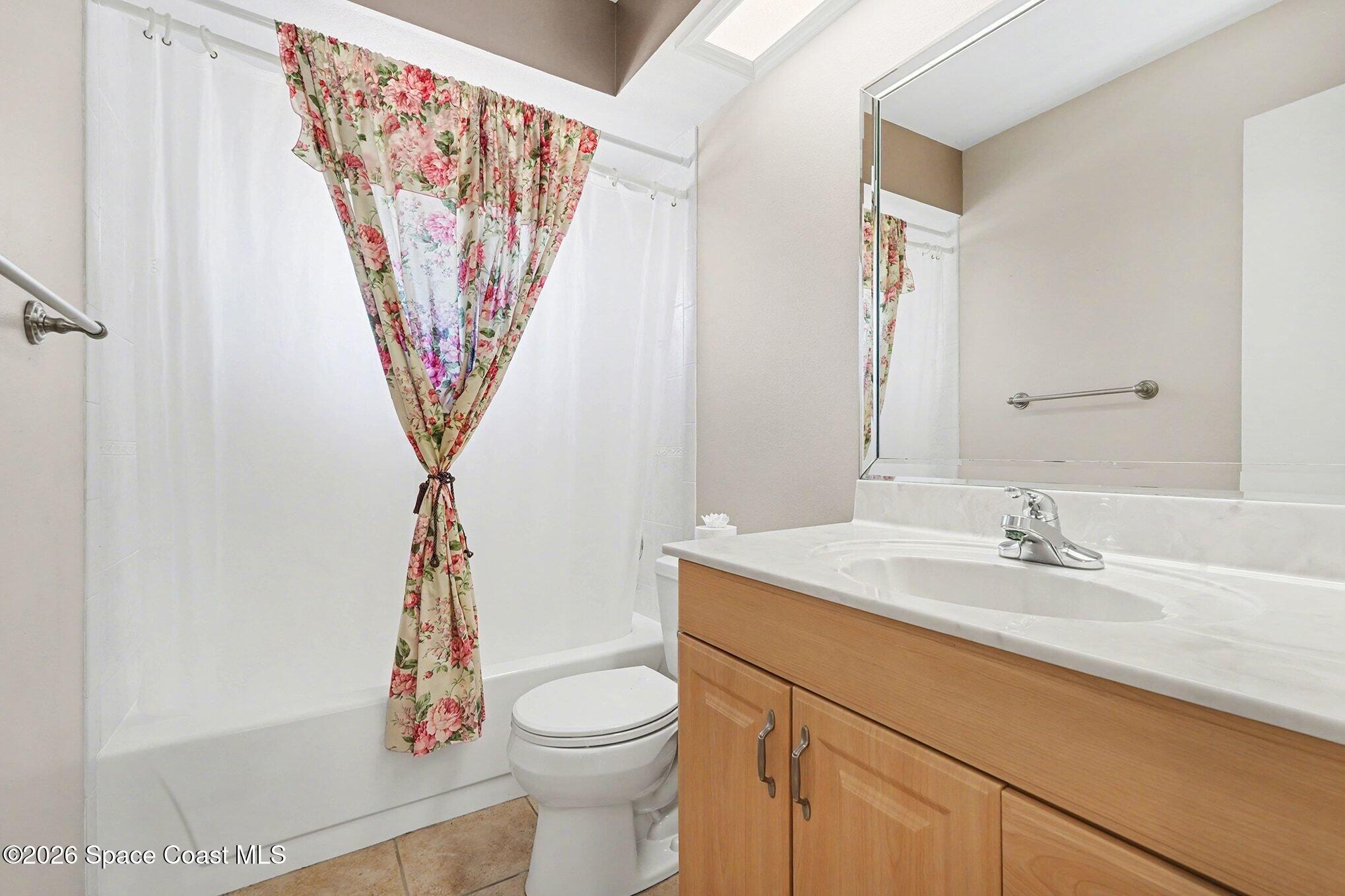 2653 Elliot Way, Unit 6 Melbourne, FL 32935 - Photo 28 of 30 a bathroom with a sink a toilet and a shower curtain