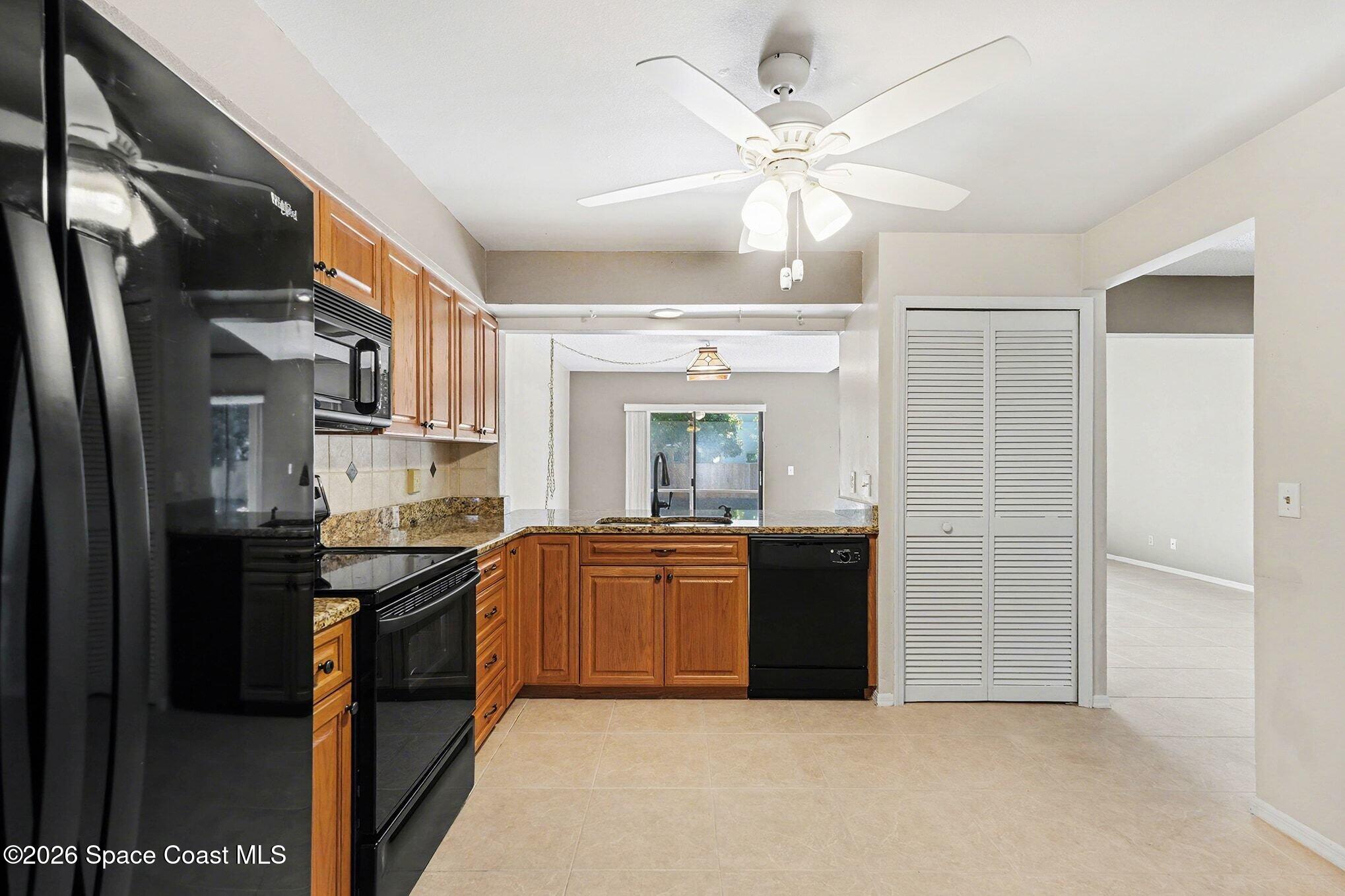 2653 Elliot Way, Unit 6 Melbourne, FL 32935 - Photo 8 of 30 a kitchen with granite countertop stainless steel appliances and wooden cabinets