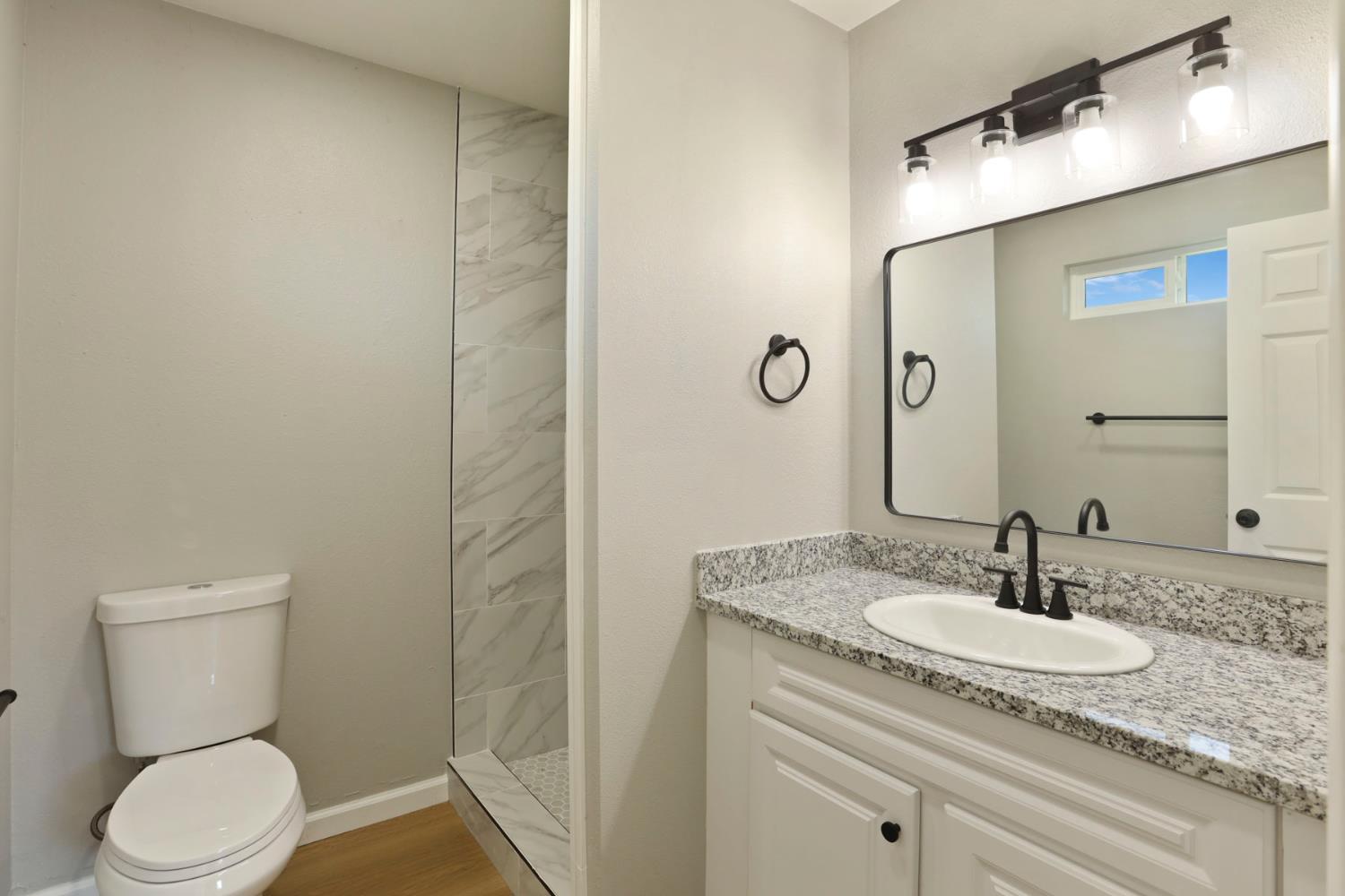 401 Church Street Modesto, CA 95357 - Photo 15 of 28 a bathroom with a granite countertop sink toilet and shower