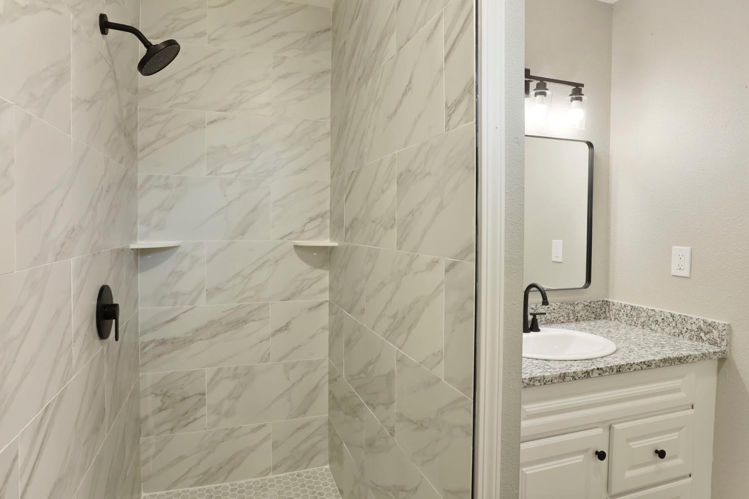 401 Church Street Modesto, CA 95357 - Photo 16 of 28 a bathroom with a granite countertop sink a mirror and shower