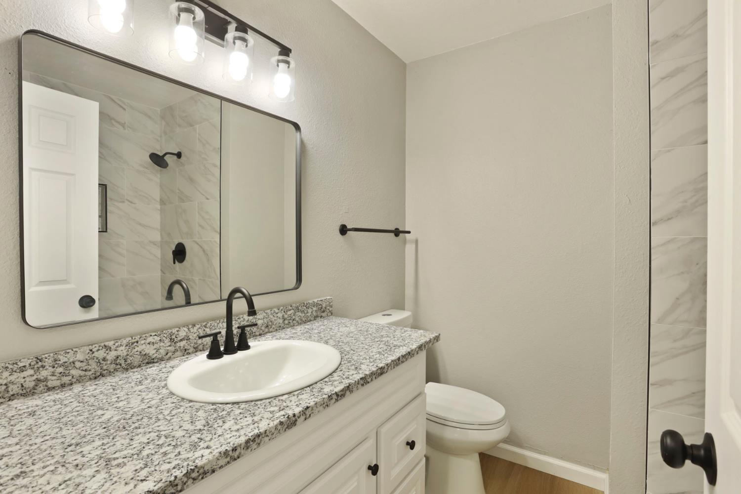 401 Church Street Modesto, CA 95357 - Photo 19 of 28 a bathroom with a granite countertop sink a mirror and a toilet