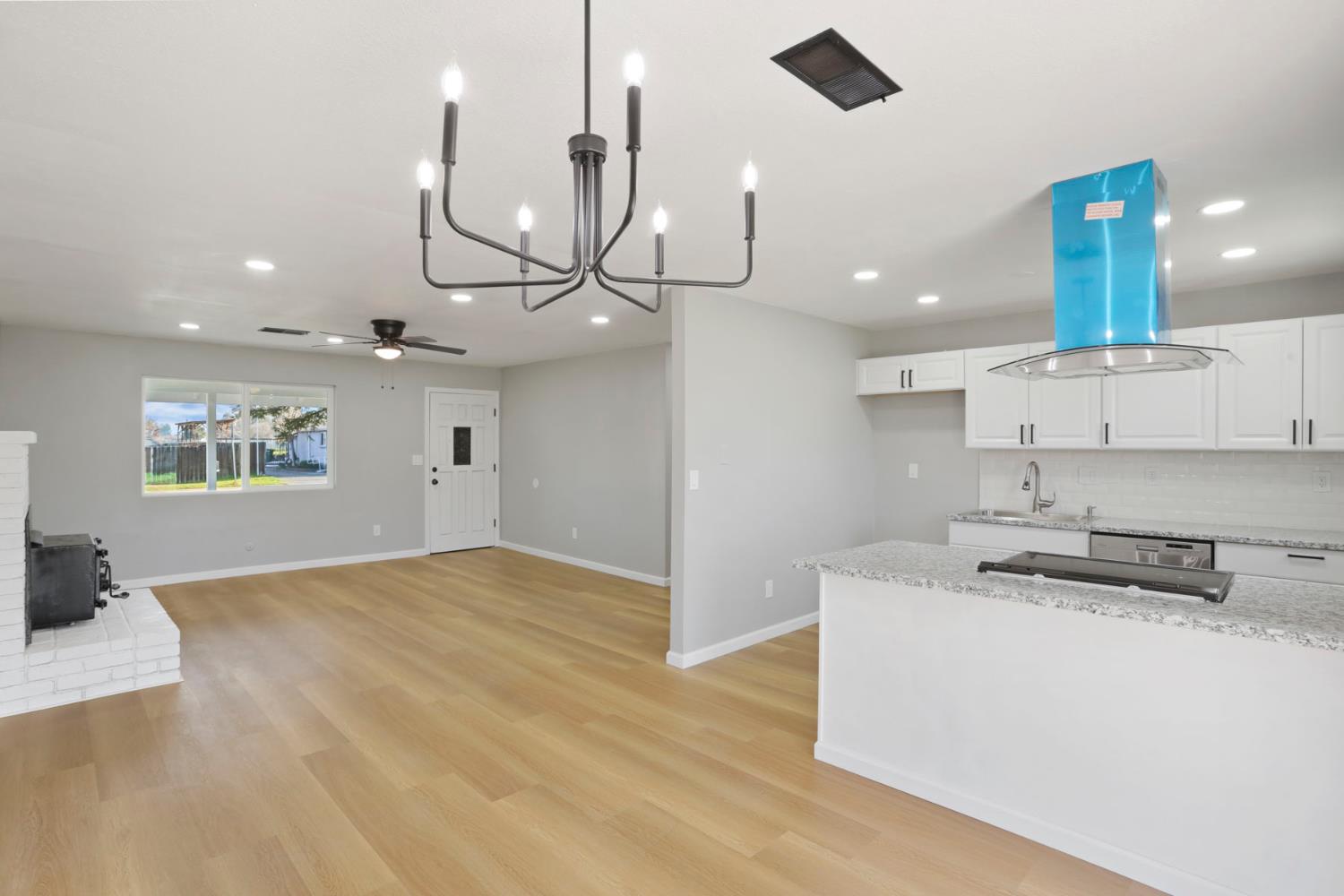 401 Church Street Modesto, CA 95357 - Photo 7 of 28 a kitchen with stainless steel appliances granite countertop a sink a stove and a wooden floor
