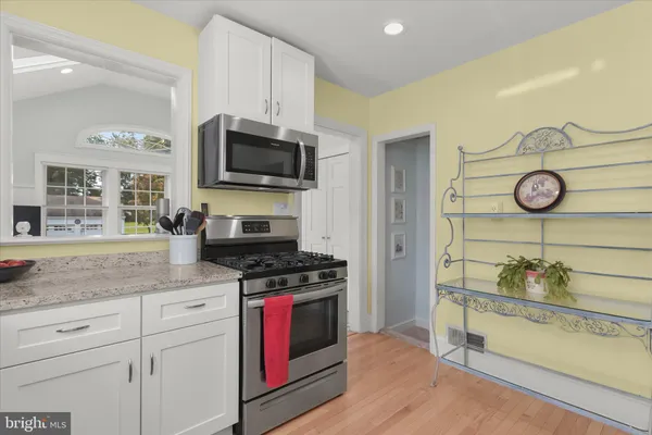 a kitchen with stainless steel appliances granite countertop a stove and a microwave