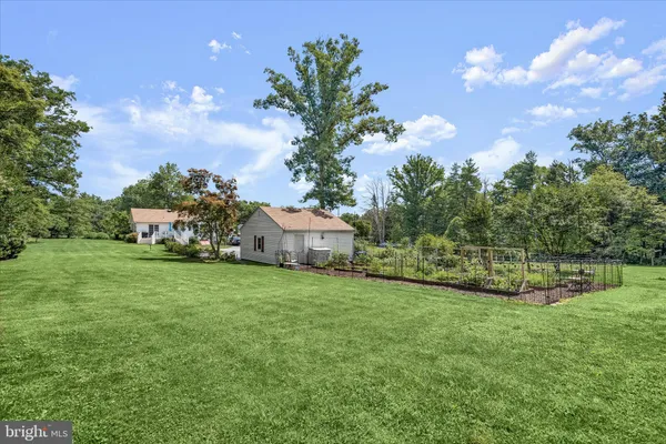 a front view of a house with a garden and trees