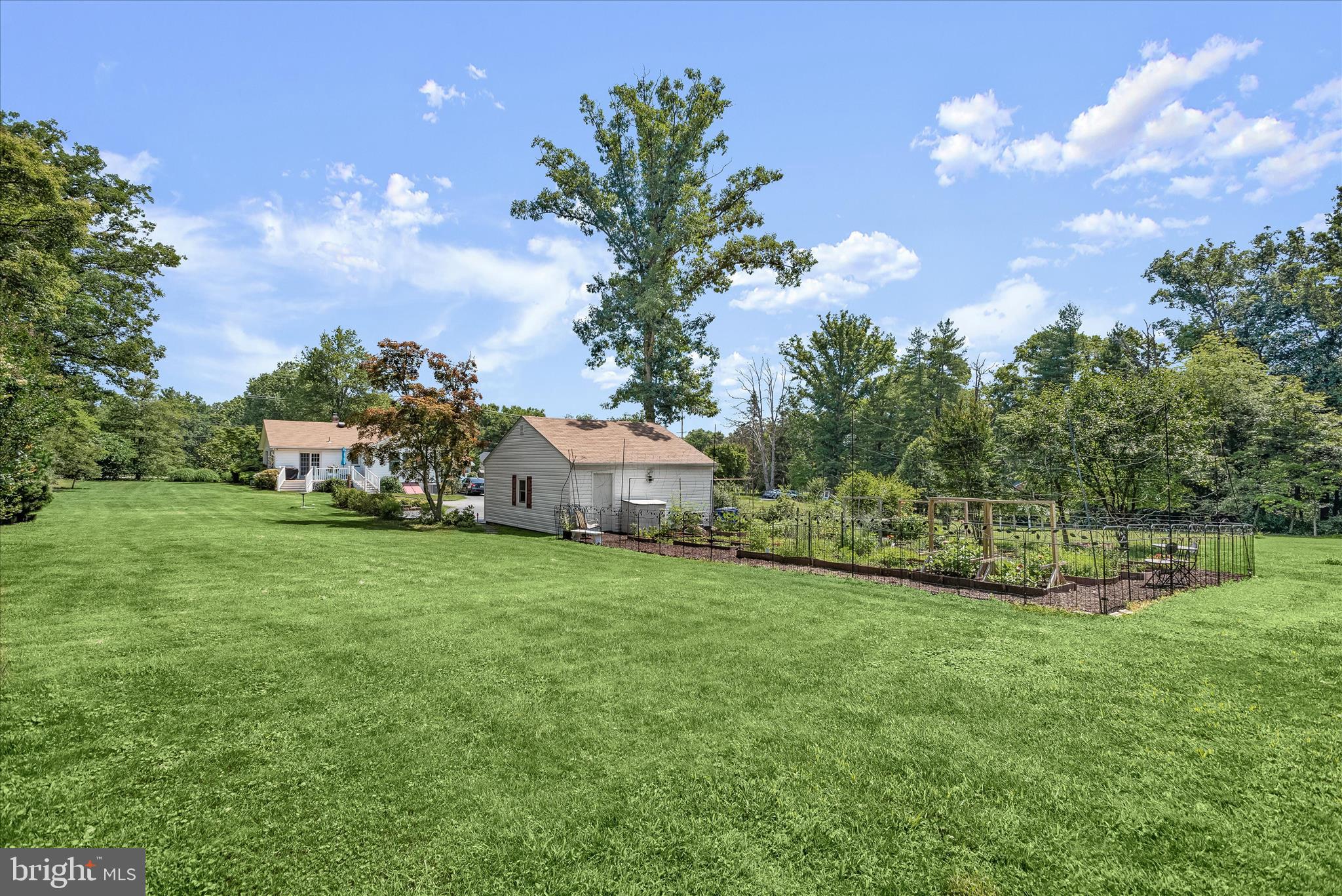 12351 Scaggsville Road Highland, MD 20777 - Photo 2 of 43 a front view of a house with a garden and trees