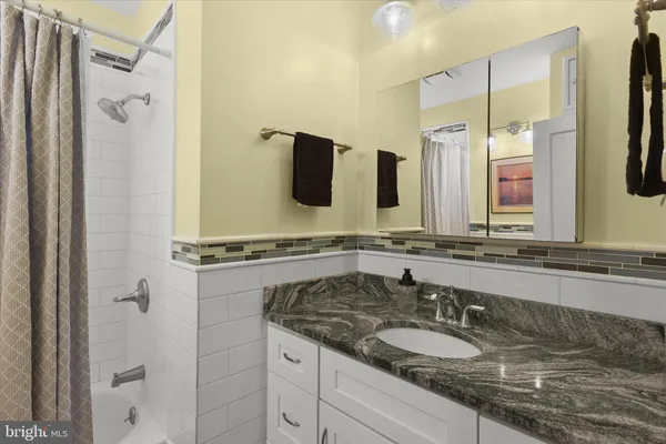 a bathroom with a granite countertop double vanity sink and mirror