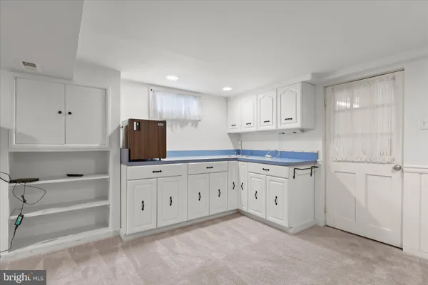 a kitchen with white cabinets and white appliances