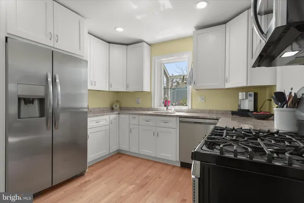 a kitchen with granite countertop a sink stainless steel appliances and cabinets