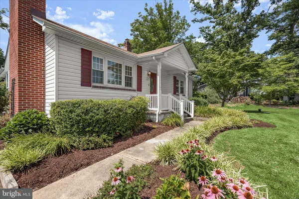 a view of a house with a yard and potted plants
