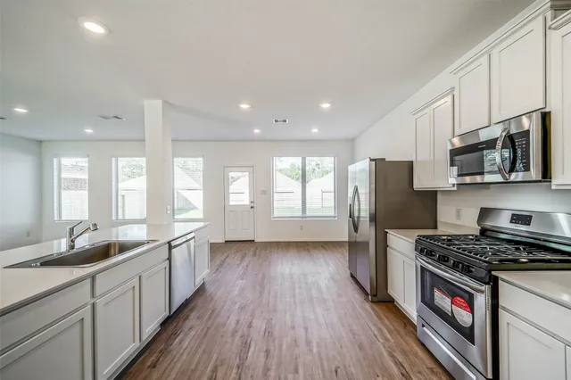 a kitchen with stainless steel appliances a stove a sink a refrigerator and cabinets
