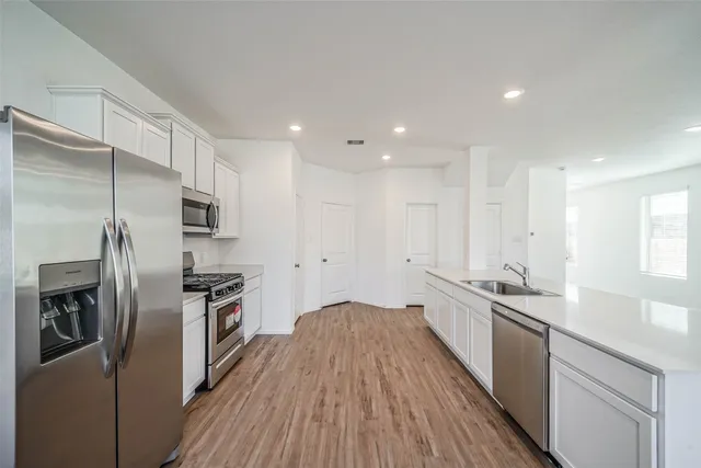 a kitchen with stainless steel appliances a refrigerator sink and stove