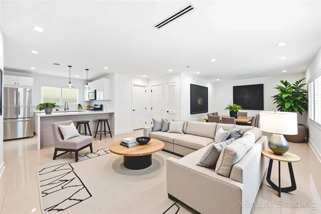 a living room with furniture kitchen view and a flat screen tv