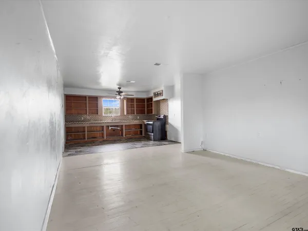 an empty room with a ceiling fan and a window