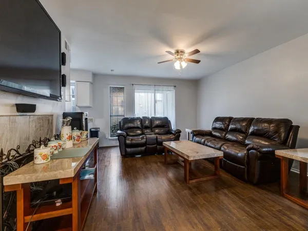 a living room with furniture a fireplace and wooden floor