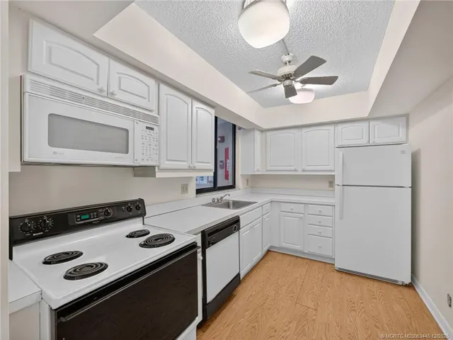 a kitchen with a stove white cabinets and black appliances