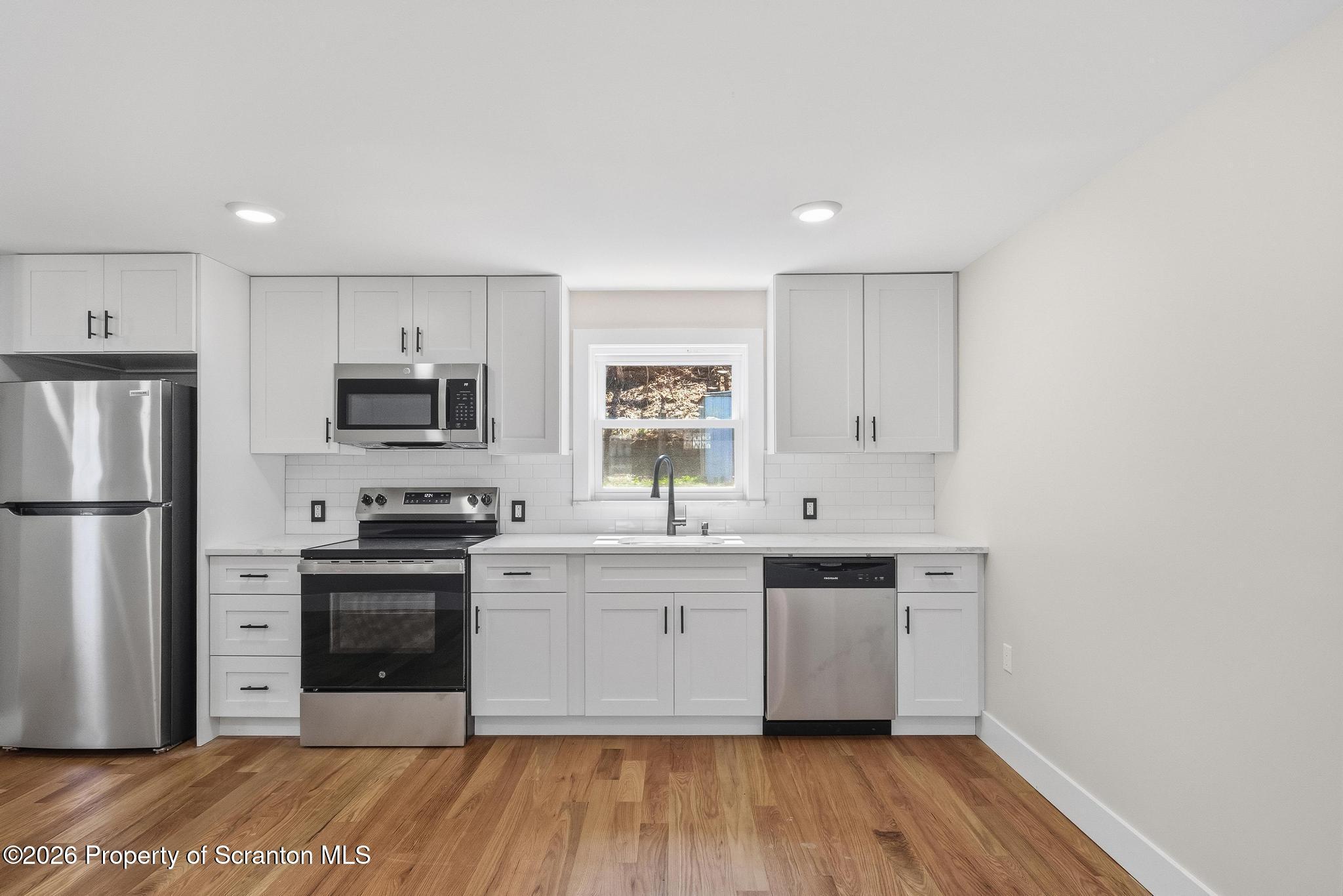 305 Parsonage Street Pittston, PA 18640 - Photo 10 of 42 a kitchen with stainless steel appliances a sink cabinets and wooden floor