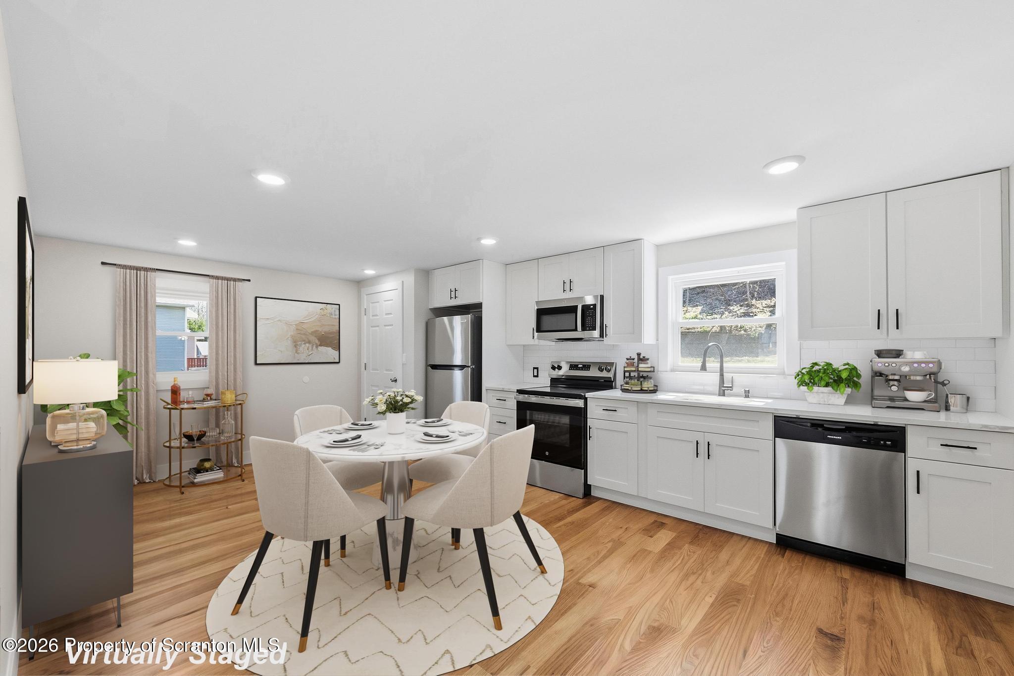 305 Parsonage Street Pittston, PA 18640 - Photo 11 of 42 a kitchen with stainless steel appliances a dining table chairs stove refrigerator and cabinets