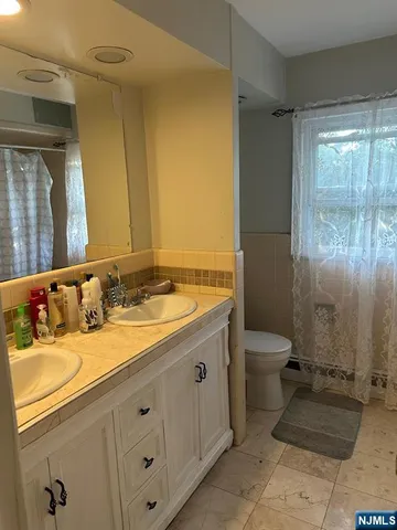 an empty room with wooden floor and windows with curtains