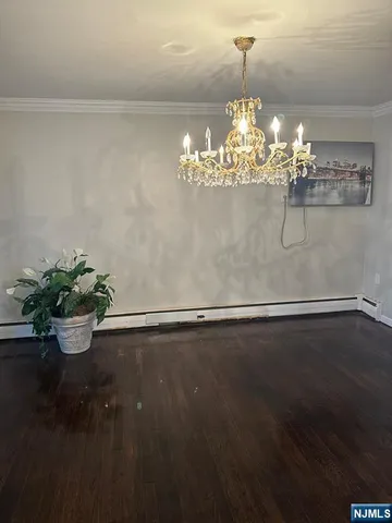 a view of a room with wooden floor a chandelier