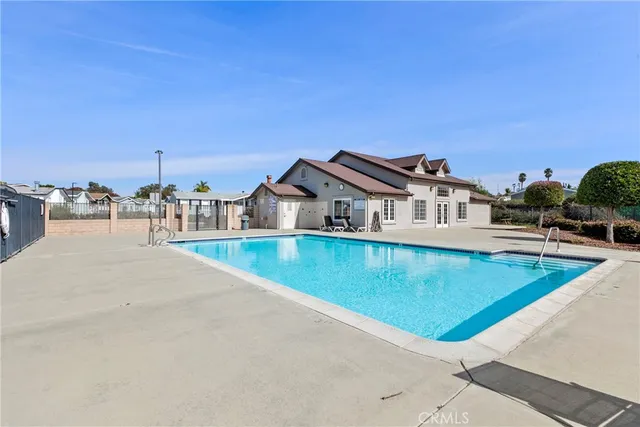 a view of a swimming pool with a lawn chairs and a fire pit