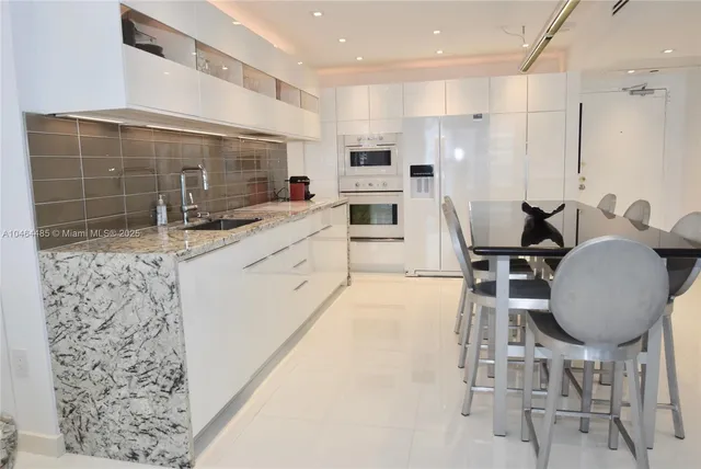 a kitchen with granite countertop a sink stainless steel appliances and cabinets
