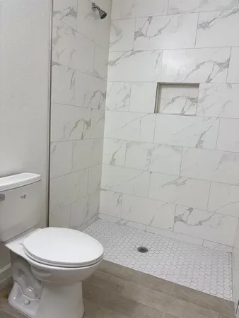 a white toilet sitting next to a shower